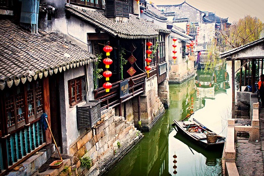 A boat outside houses in Shanghai.